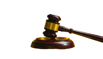 A wooden gavel, with golden accents, rests upon its sound block against a black backdrop