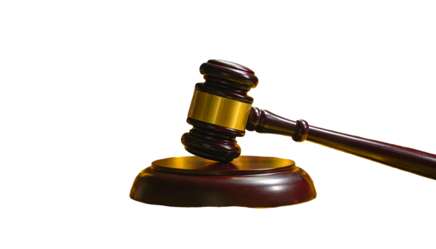 A wooden gavel, with golden accents, rests upon its sound block against a black backdrop