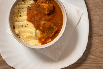 Goulash with beef and carrots with mashed potatoes top view on wooden table