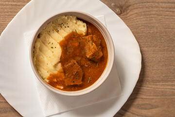 Goulash with beef and carrots with mashed potatoes top view on wooden table