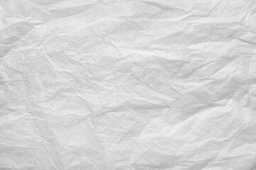 Obraz premium Crumpled white paper sheet with creases and wrinkles forming textured, distressed abstract background with copy space and vintage feel