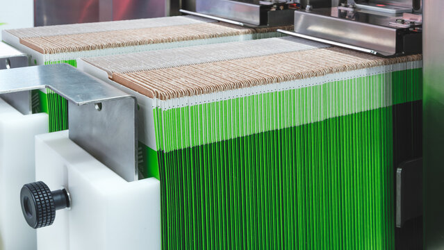 Folded cardboard boxes stand in a row on a packaging machine conveyor ready to be opened and filled with food products.