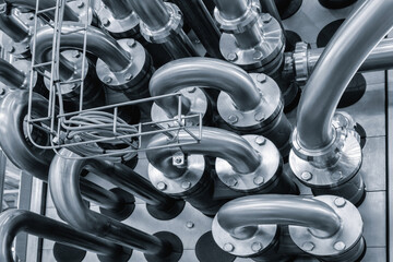 Stainless steel pipes attached to stainless steel tank with industrial food production machine,...