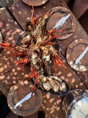 Grilled seafood platter on rustic wooden table in sunlight
