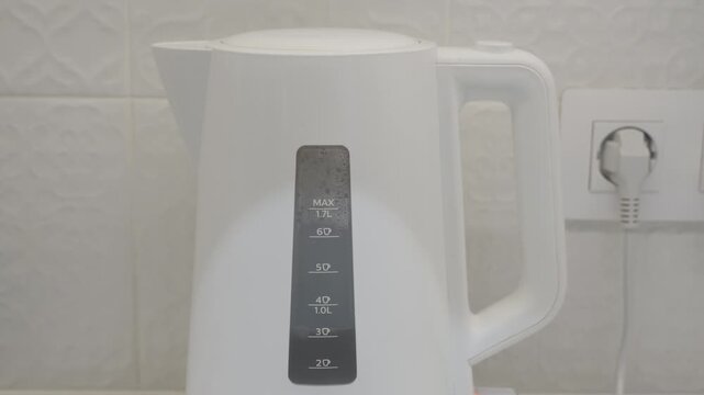 White Electric Kettle Boiling Water, Preparing Tea for a Relaxing Break.
