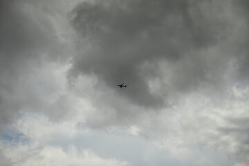 An airplane in the sky. An airplane against gray clouds.