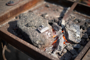 Melting metal in an open furnace. Blacksmith's furnace. Forging steel.