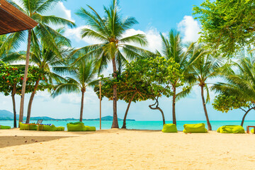 Tropical beach on Koh Samui island with green bean bags, palm trees, golden sand and turquoise sea under sunny blue sky, Thailand. Eco tourism, beach resorts and tropical escape in Asia