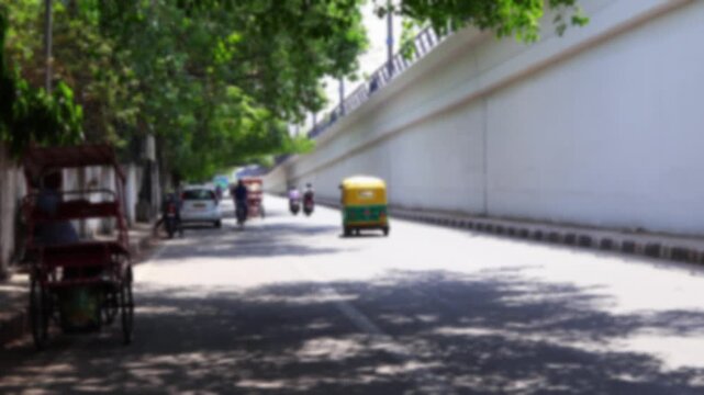 Blurry view of calm vehicle daytime traffic near Connaught Place in Delhi, india. Bokeh real time motion video for background.