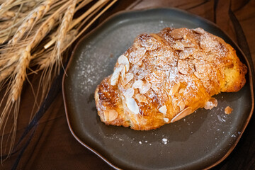 Close up delicious breakfast menu croissant and coffee cup on the wood table in the restaurant.