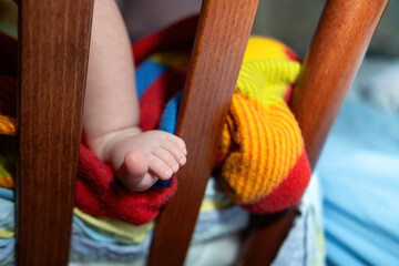 A small child's foot stuck between crib slats, demonstrating a potential injury hazard