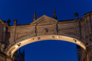 Obraz premium Illuminated ancient stone arch at twilight
