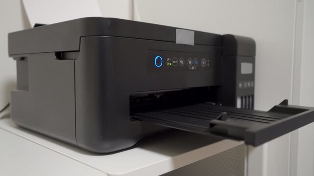 Process Commences: Hand Turns On Printer, Operational Whirring Echoing.