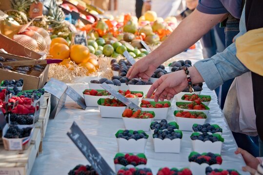 Clients en train de choisir des fruits et l&eacute;gumes frais sur un march&eacute; ensoleill&eacute; de Nice, c&ocirc;te d'azur