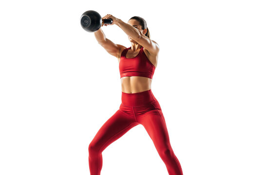 Fit woman in red sportswear performing a kettlebell swing