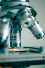 Laboratory microscope with illuminated slide symbolizing clinical research