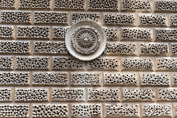 Textured brick wall with ornate circular decoration