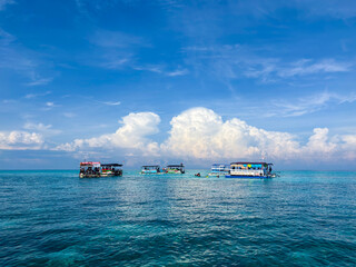 Experience paradise with a stunning boat tour on crystal clear turquoise waters under blue skies and fluffy clouds