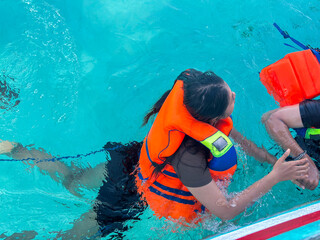 Enjoying a refreshing swim with life vest in crystal clear turquoise tropical waters on summer vacation