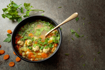 Classic meatball soup with potatoes,  carrot and greens.
