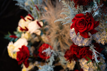 Elegant wedding table floral arrangement with fresh roses, peonies, and greenery. Romantic centerpiece decoration for a wedding reception or banquet, featuring soft pastel colors and delicate blooms c