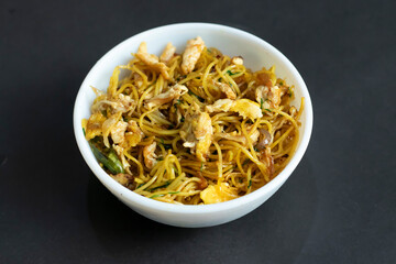 delightful egg noodles chow mein presented in a clean white bowl, offering a perfect blend of textures and flavors for any dining occasion.