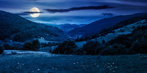 panoramic rural landscape with village in mountains at night. beautiful countryside behind the...