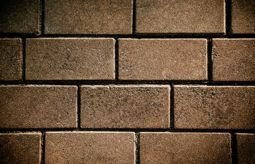 Fototapeta premium Brown stone pavement with textured rectangular tiles. Natural background. Close-up.