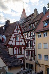 Obraz premium Colorful Bavarian timber-frame houses in Tiergärtnertorplatz, , with the historic city walls and castle towers creating a charming medieval atmosphere.