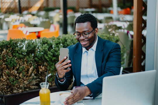 Black businessman using smartphone remote working at cafe