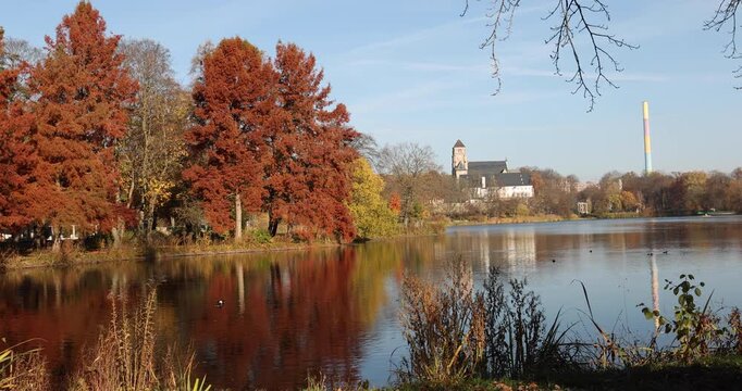 Calm waters of the pond in the public park of Chemnitz during a clear autumn day.