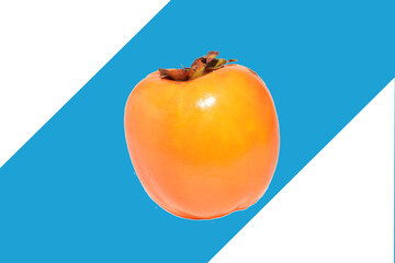 Persimmon, the fruit of a subtropical tree, on a blue background.
