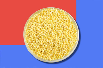 Yellow cereal called millet in a plate.