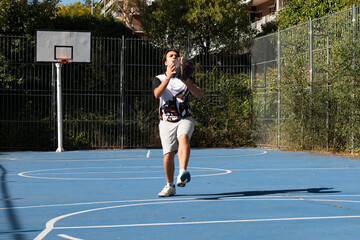 Young man playing basketball on an outdoor court