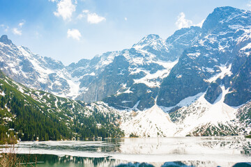 landscape with lake in tatra mountains of poland in spring. snow covered rocky peaks. outdoor adventure and vacation season on morskie oko © Lesia