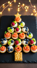 Festive appetizer Christmas tree on black slate with fairy lights. A delicious and joyful holiday presentation. Christmas party, new year's eve, holiday cheer.
