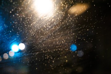 Abstraktes Motiv mit bunten und weißen Lichtern vor schwarzem Himmel bei Regen, Sturm und Kälte in der Nacht im Herbst 