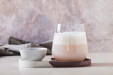 Cloudy pink matcha in a glass with airy foam on the table