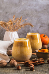 Warming pumpkin nut latte in glasses on the table vertical view
