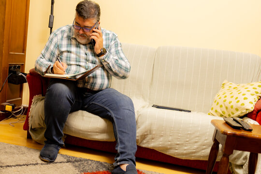 Man multitasking working from home talking on phone