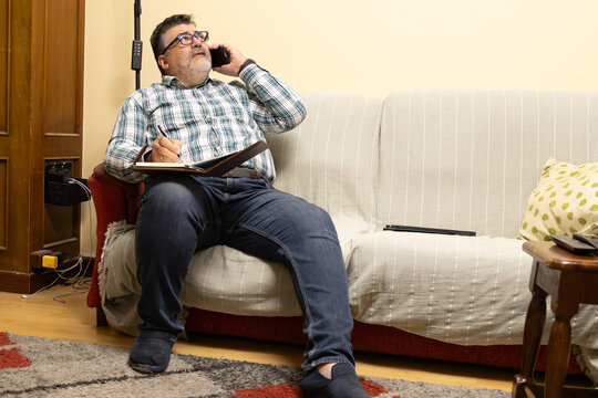 Man multitasking working from home with phone call