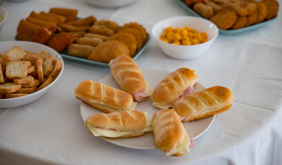 Detalhe de comida, pãezinhos com queijo e fiambre e varias entradas para cerimonia. 