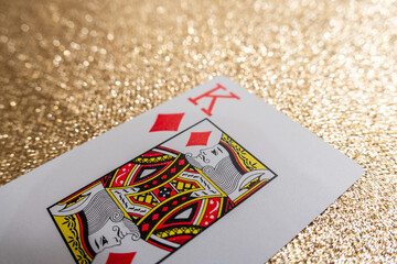 Photograph of a red king of diamonds playing card on a gold background