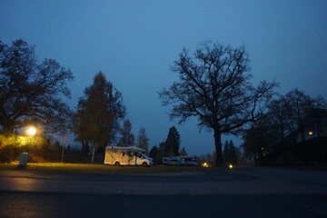 Angeleuchteter einsamer Wohnmobilplatz in der Nacht im Herbst