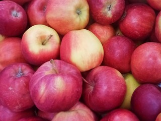 Close-up view of fresh ripe red apples with natural texture and soft lighting. The vibrant colors and smooth skin highlight freshness and organic quality. Perfect for illustrating healthy eating, natu