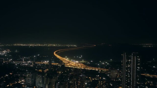 India's longest sea bridge: Trans-Harbour Sea Link. Atal Setu sea bridge in Mumbai, Maharashtra, India. Time-lapse of a city at night with bright skyscrapers and a dense network of glowing buildings.