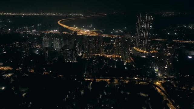 India's longest sea bridge: Trans-Harbour Sea Link. Atal Setu sea bridge in Mumbai, Maharashtra, India. Time-lapse of a city at night with bright skyscrapers and a dense network of glowing buildings.