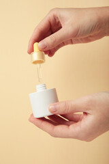 Beauty cosmetic skincare oil in bottle on beige background. Elegant mockup for skincare, serum, or beauty branding presentations.