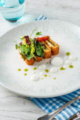 Crispy fish roulade with greens and white sauce drops