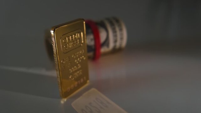 Gold ingot and a roll of american dollars symbolize wealth, finance, and investment success